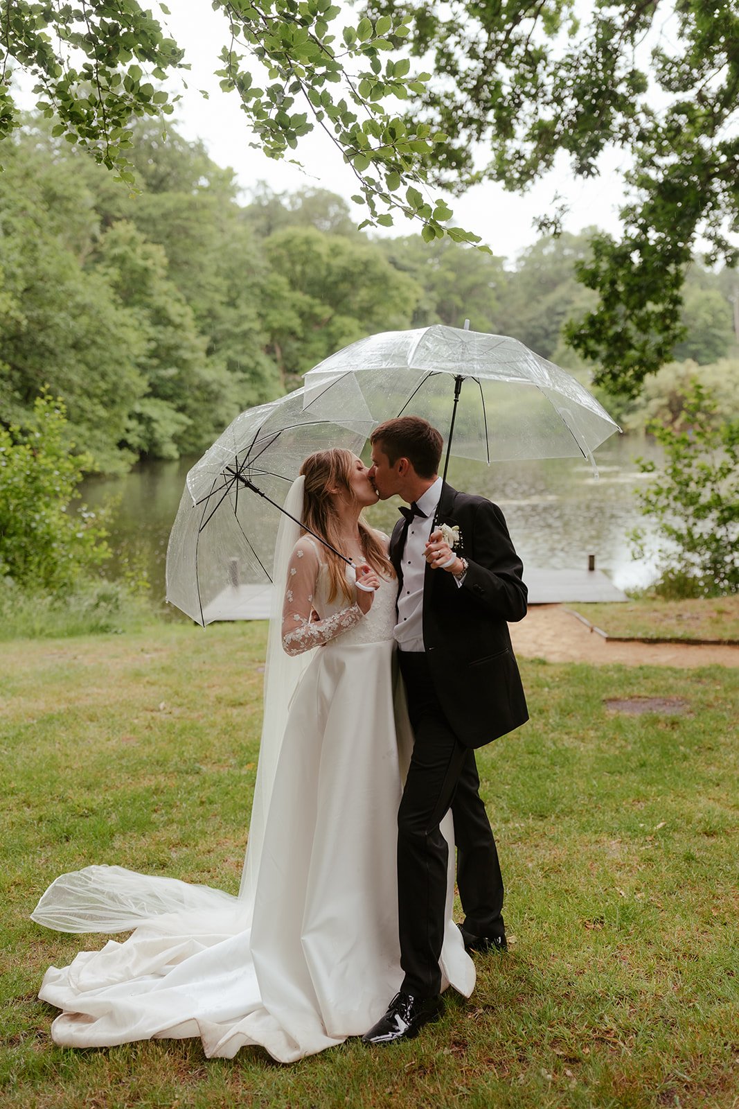 Bride and groom portrait in the grounds at Worstead Estate with umbrellas