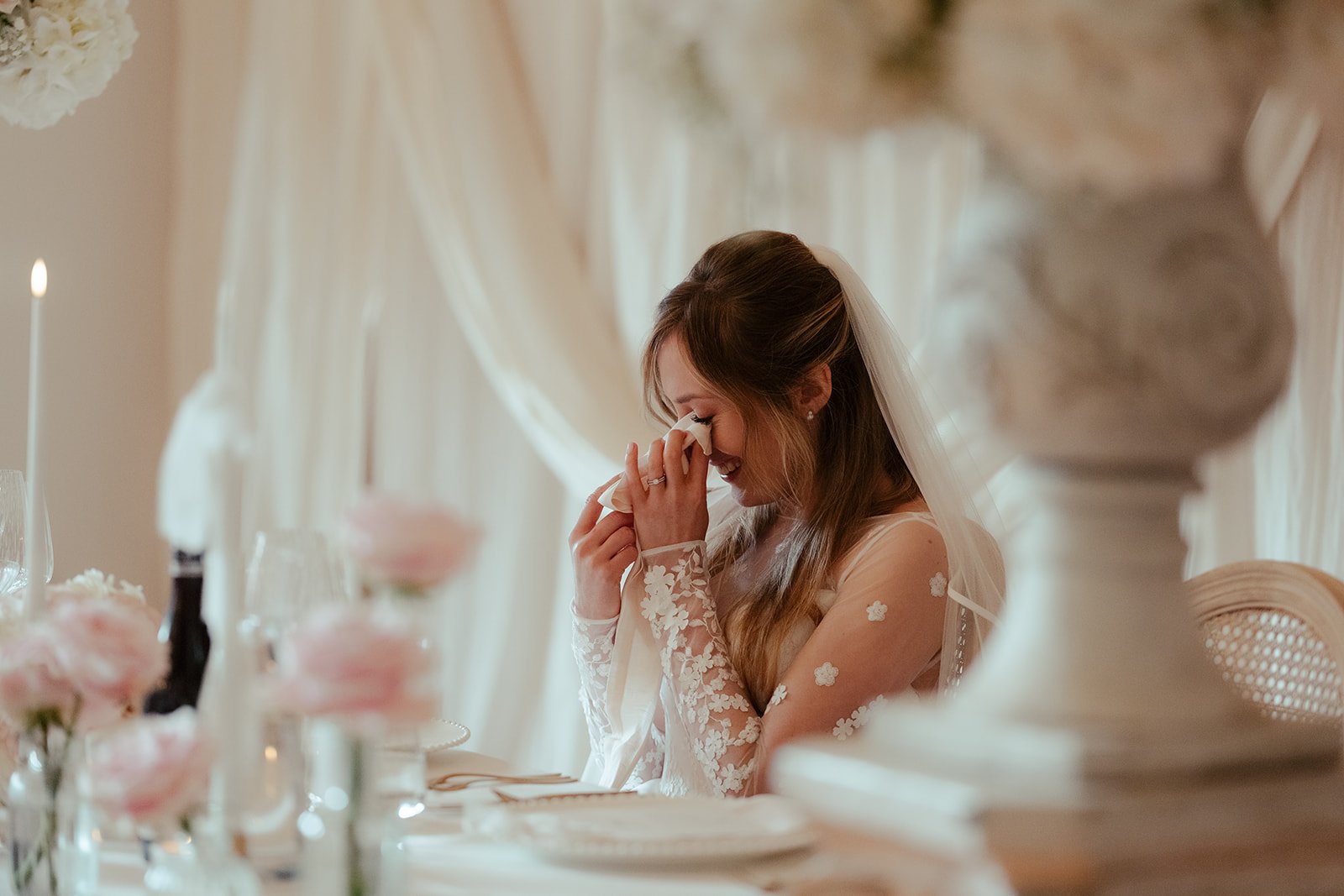 The bride crying with laughter at the top table at Worstead Estate