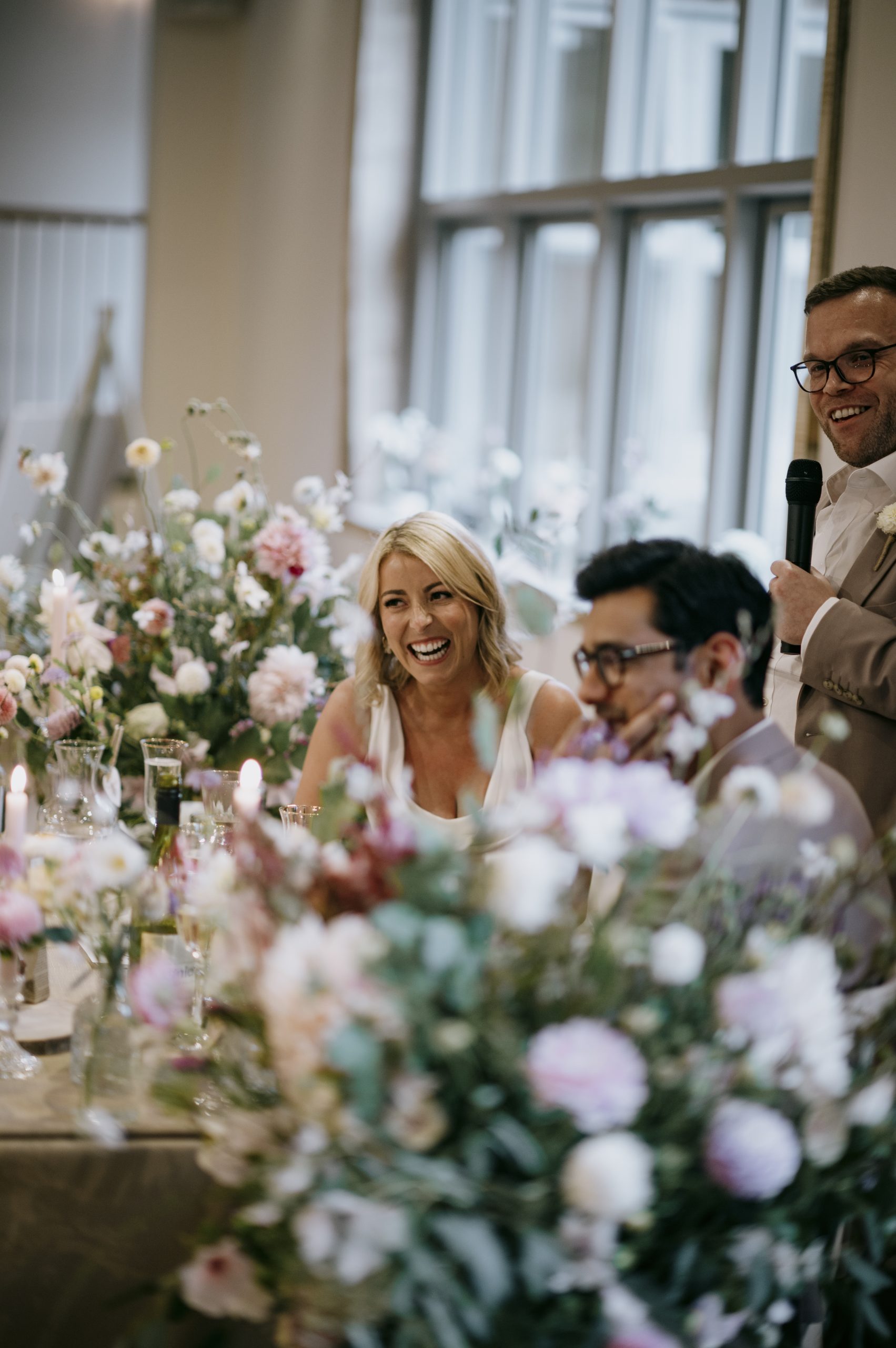 The bride and groom enjoying themselves at the top table on their wedding day at Worstead Estate