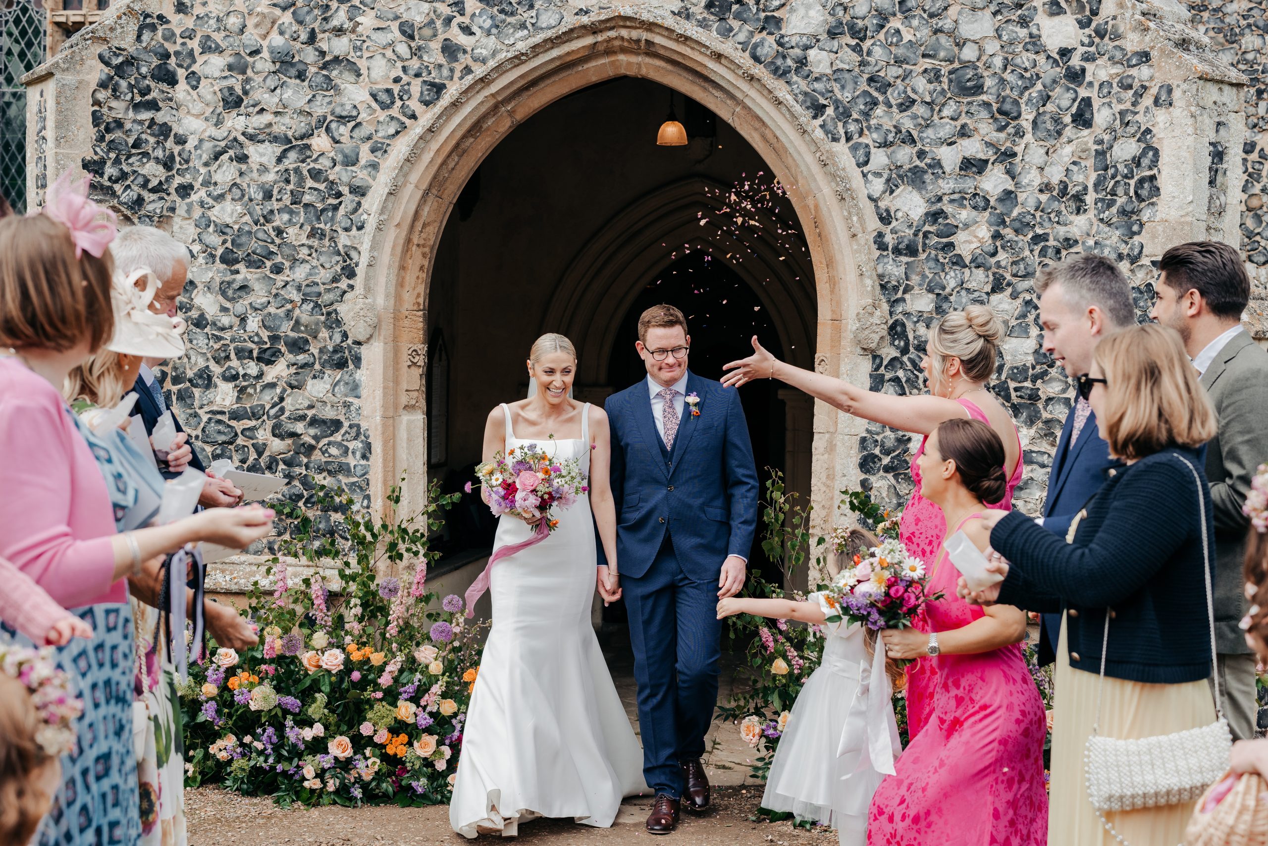 bride and groom enjoying confetti after church service on their wedding day with wedding guests, coordinated by Hardesty Event Design