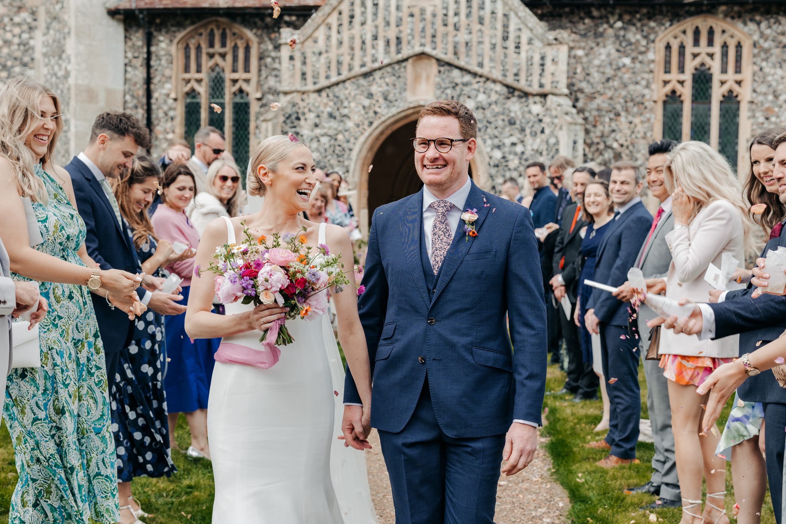 bride and groom on their professionally planned wedding day with wedding guests surrounding them