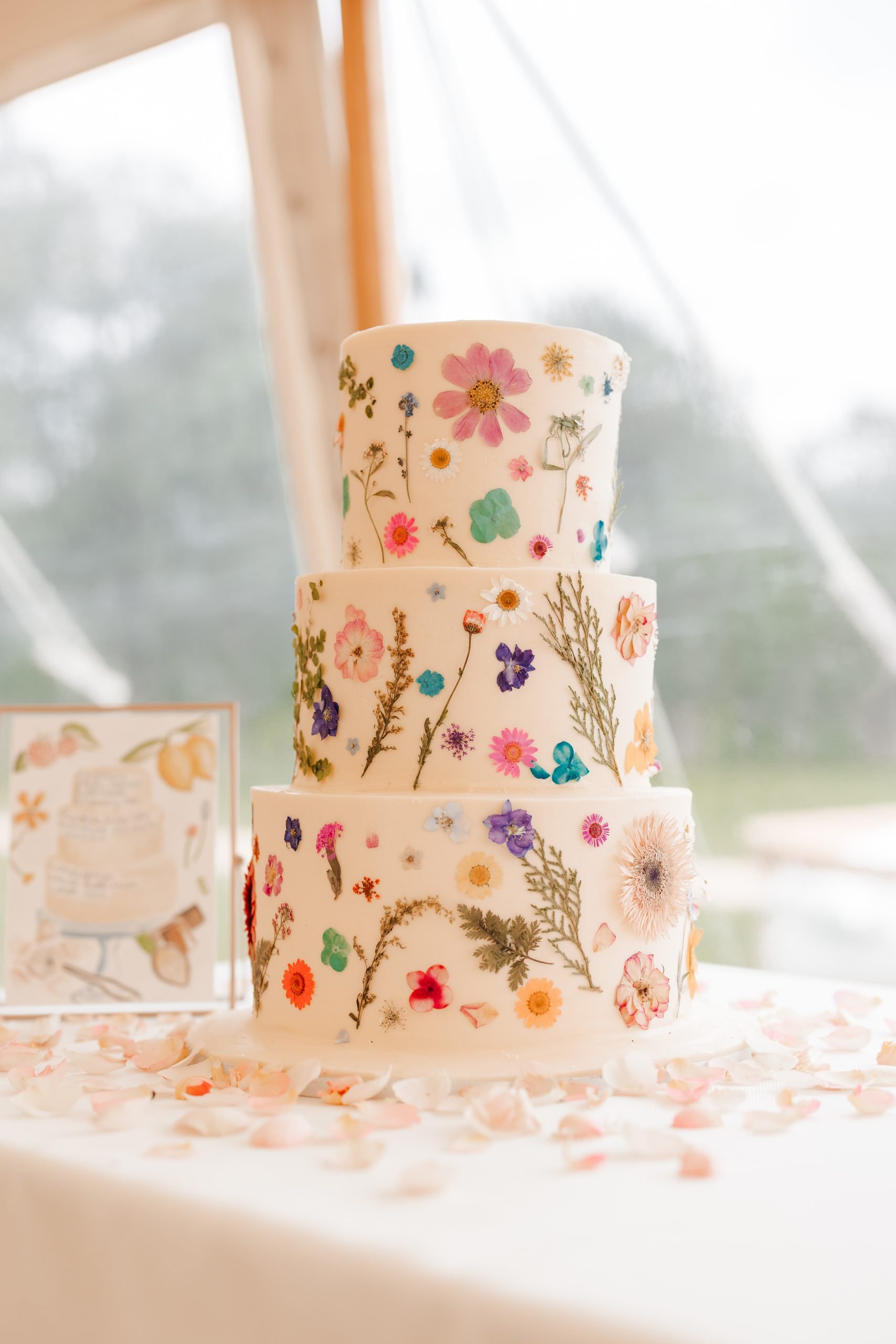 floral wedding cake at a stylish marquee wedding at Helmingham Hall in Suffolk on Emma and Luke's wedding day