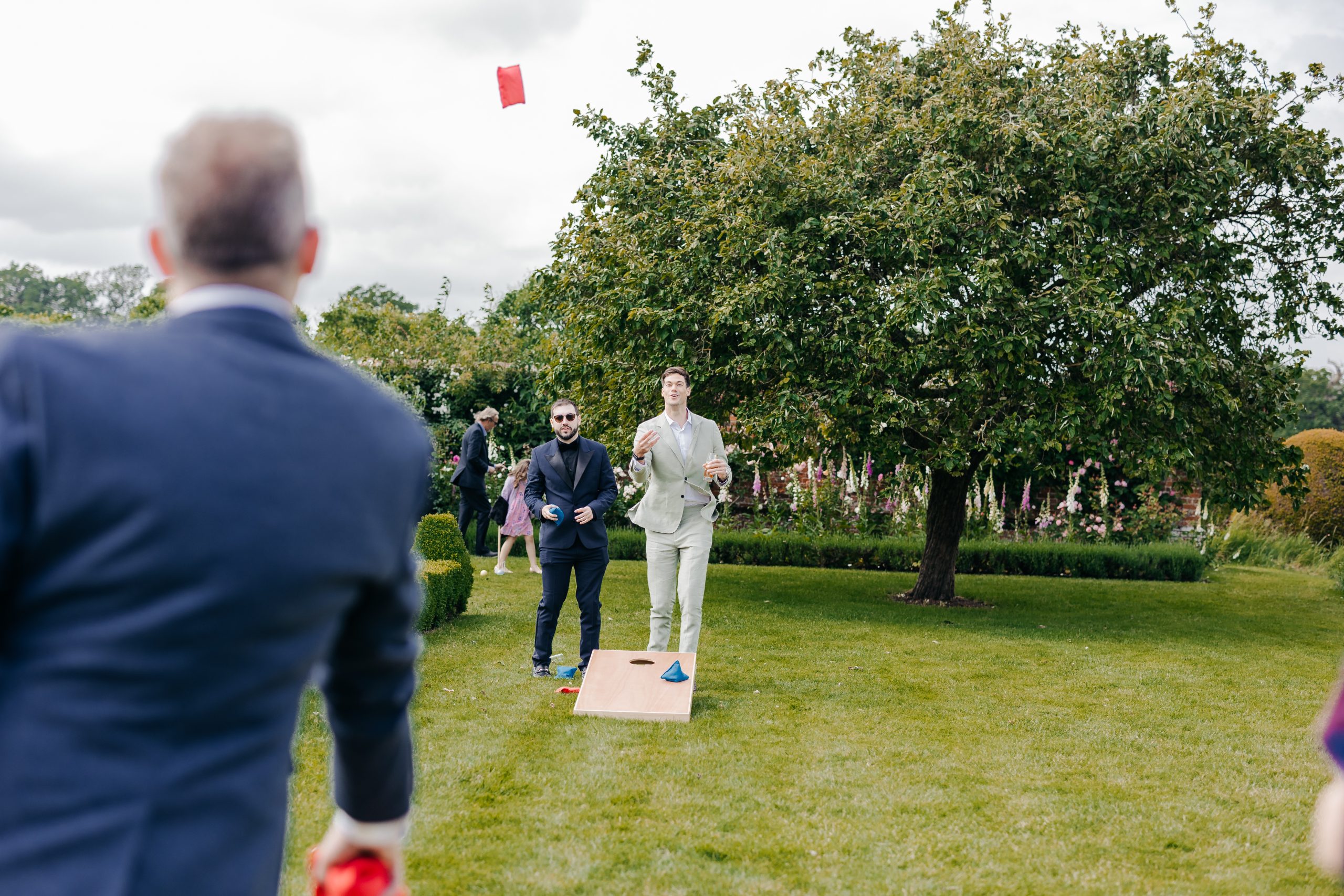 Wedding guests enjoying the grounds of Helmingham Hall in Suffolk on the wedding day of Emma and Luke, coordinated by Hardesty Event Design