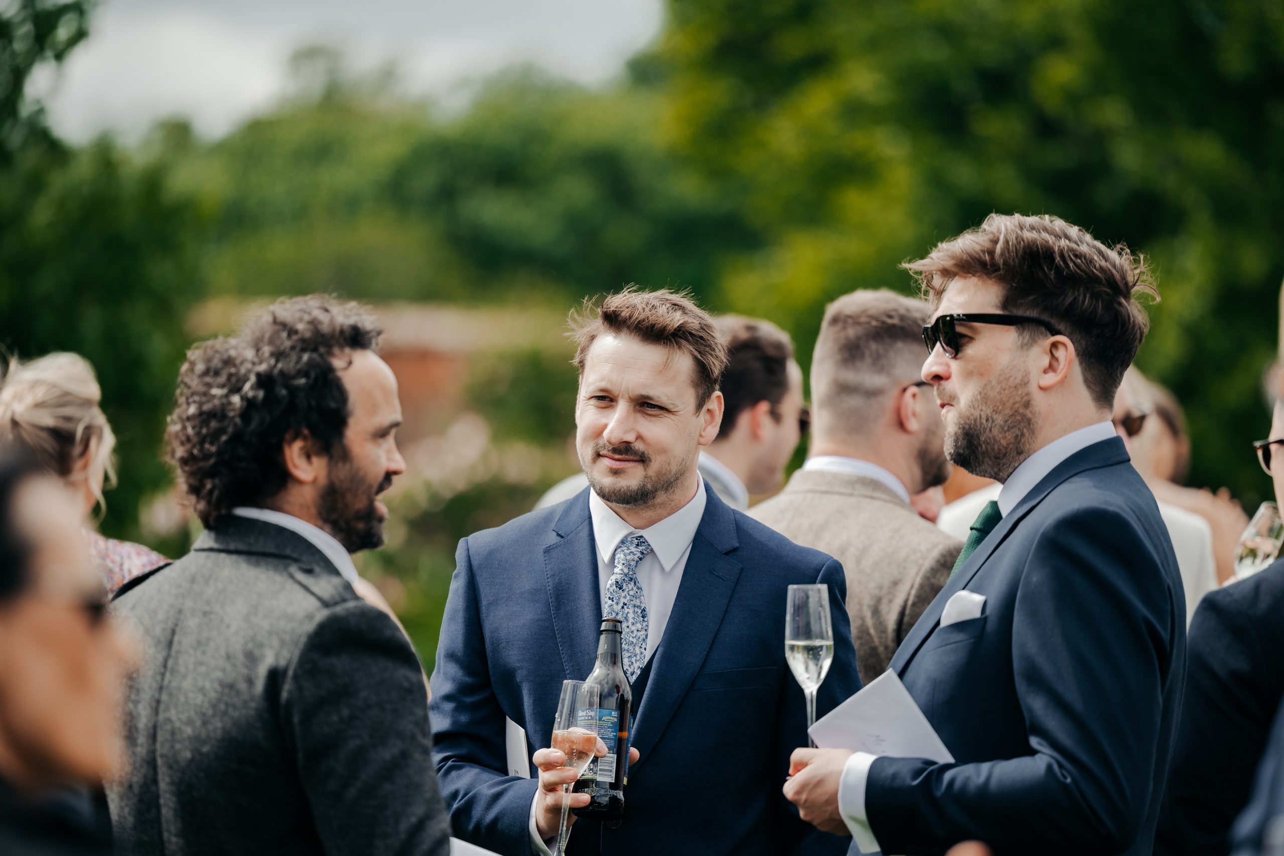 wedding guests enjoying a champagne reception at a marquee wedding in Suffolk, planned by Hardesty Event Design, UK wedding planners