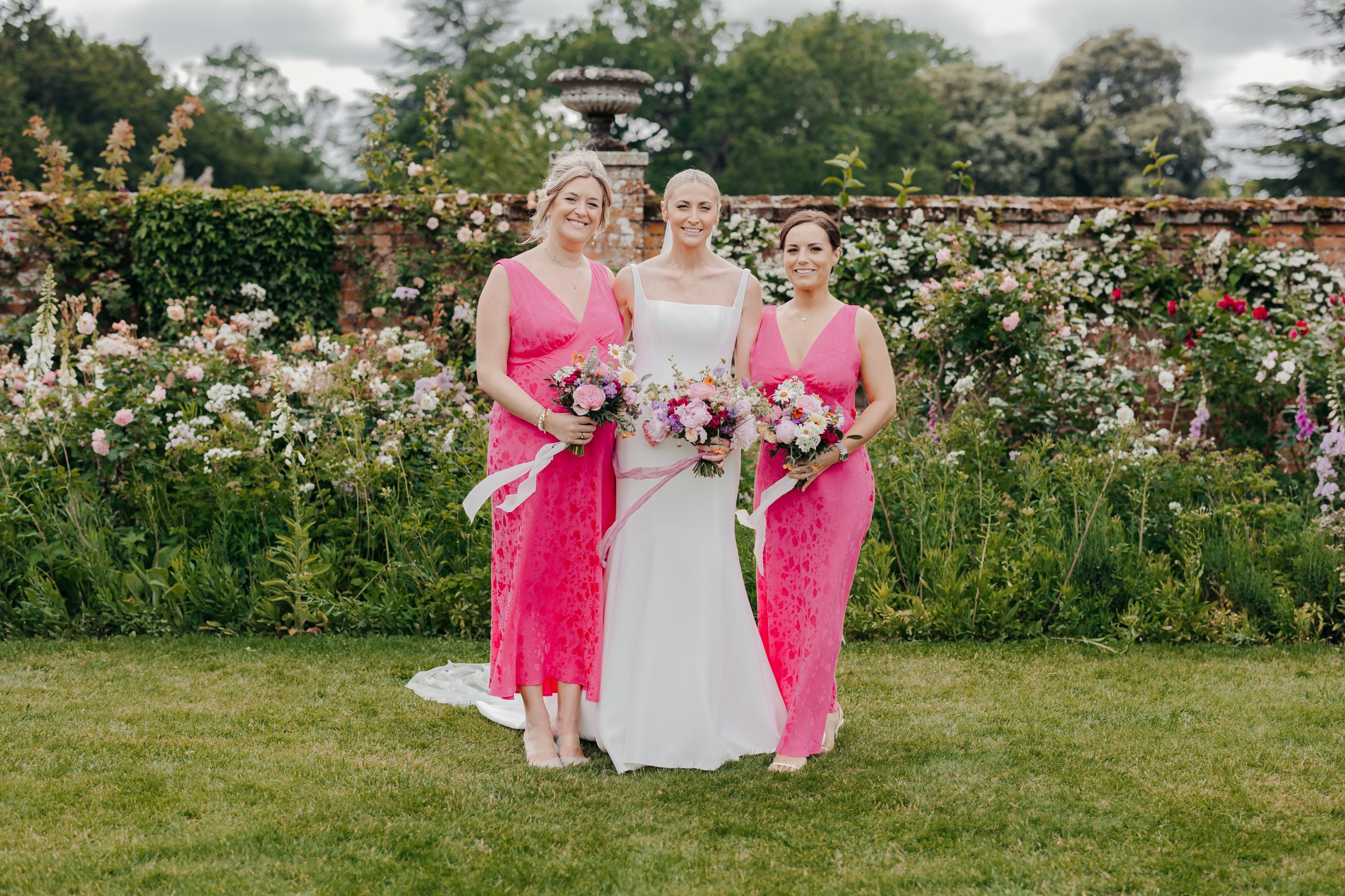 bride and her bridesmaids in the grounds of Helmingham Hall, Suffolk on her marquee wedding day
