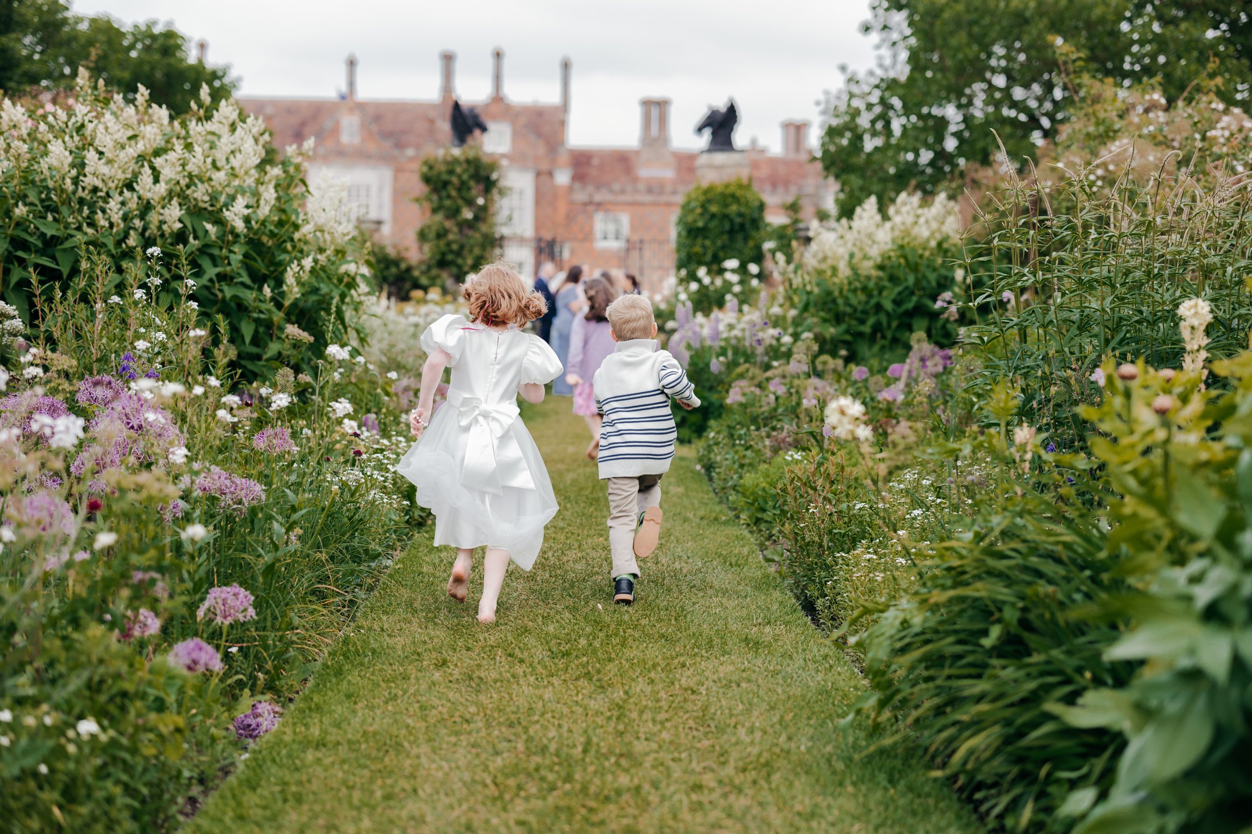 Wedding guests enjoying a champagne reception at a marquee wedding in Suffolk, planned by UK wedding planners