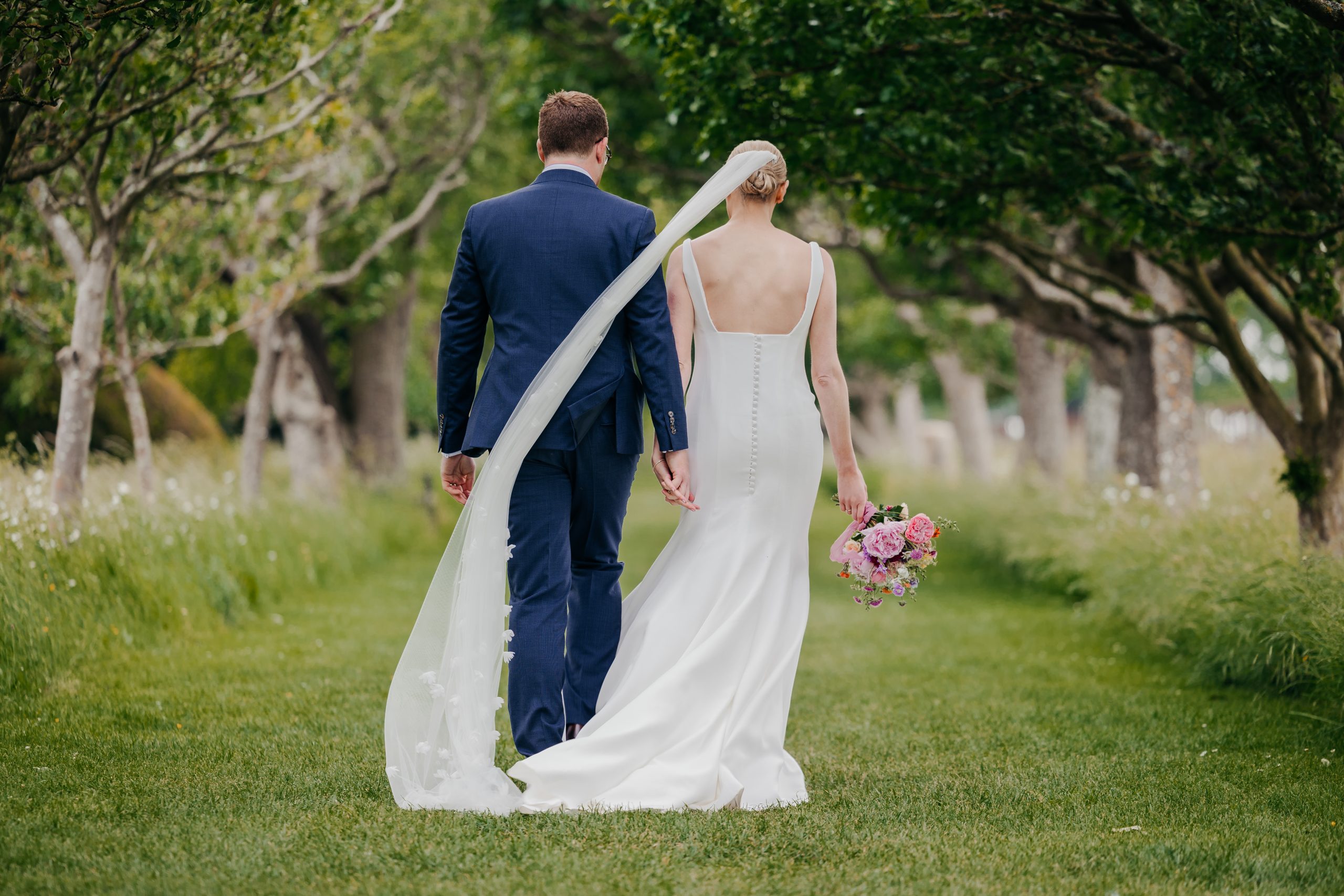 Bride and groom portrait in the grounds of Helmingham Hall during their marquee wedding