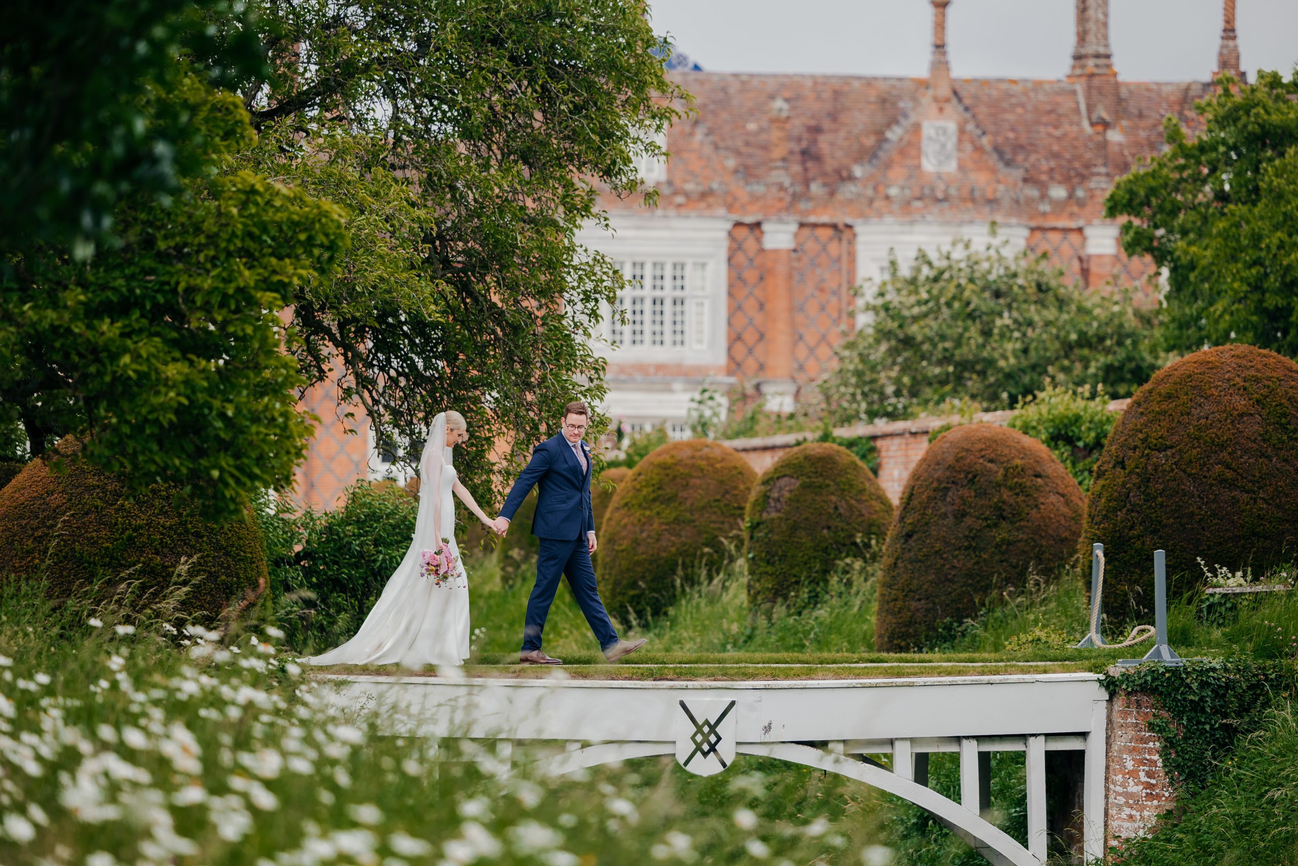 Emma & Luke sharing a moment outside their marquee, in the grounds of Helmingham Hall, styled by a high-end UK wedding planner