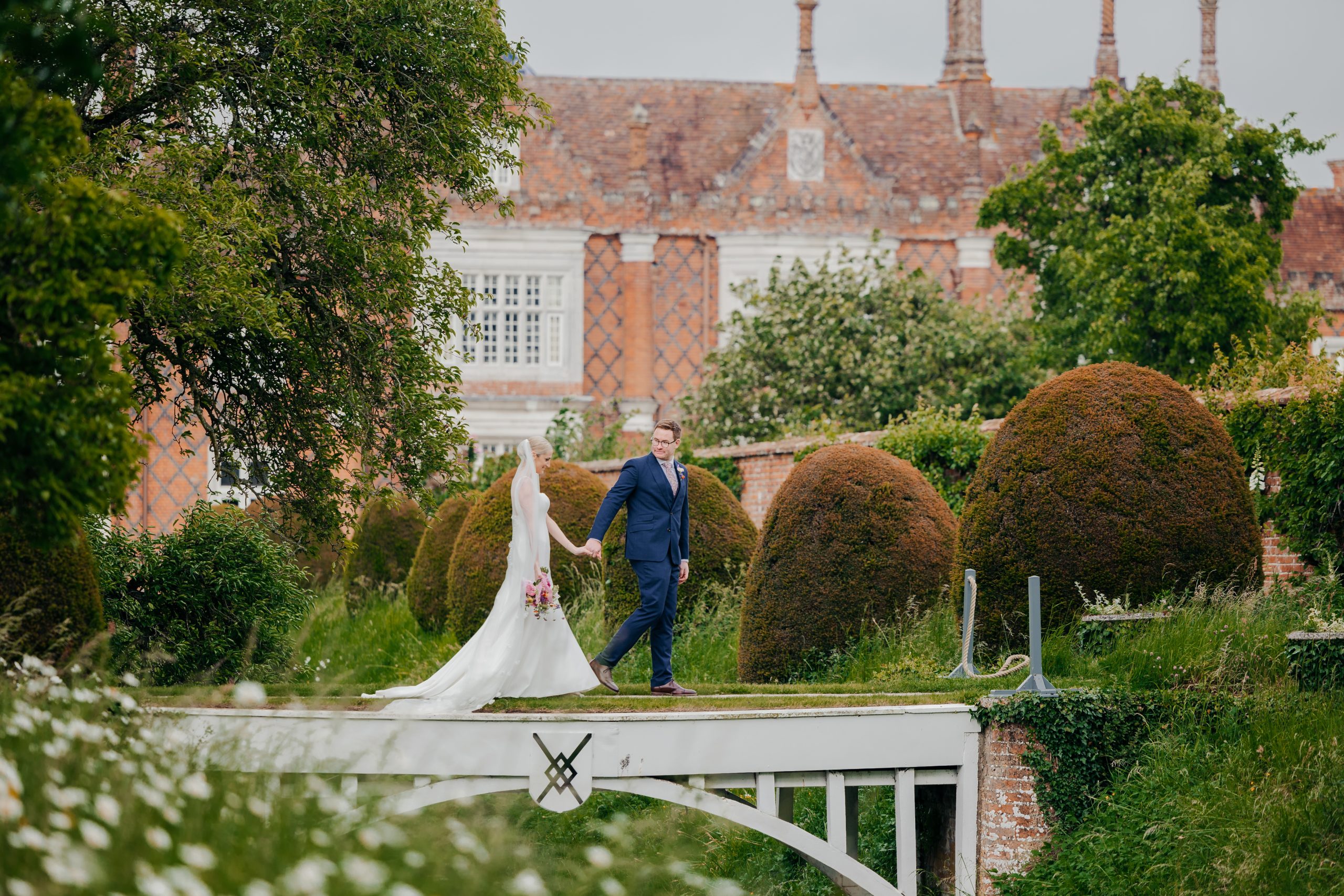 Emma & Luke sharing a moment outside their marquee, in the grounds of Helmingham Hall, styled by a high-end UK wedding planner