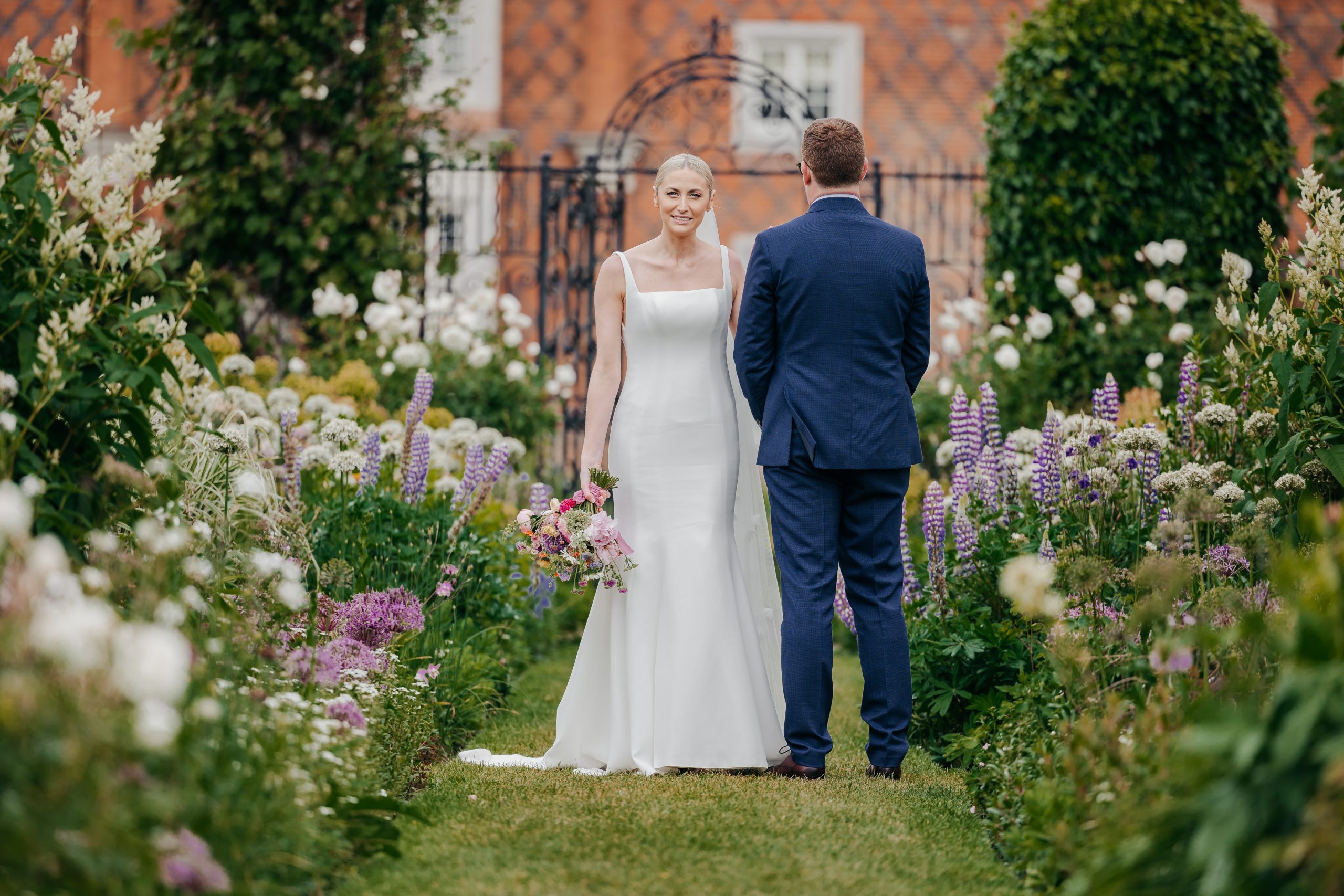 Emma & Luke sharing a moment in the grounds of Helmingham Hall, a country house wedding venue in Suffolk, styled by a high-end UK wedding planner