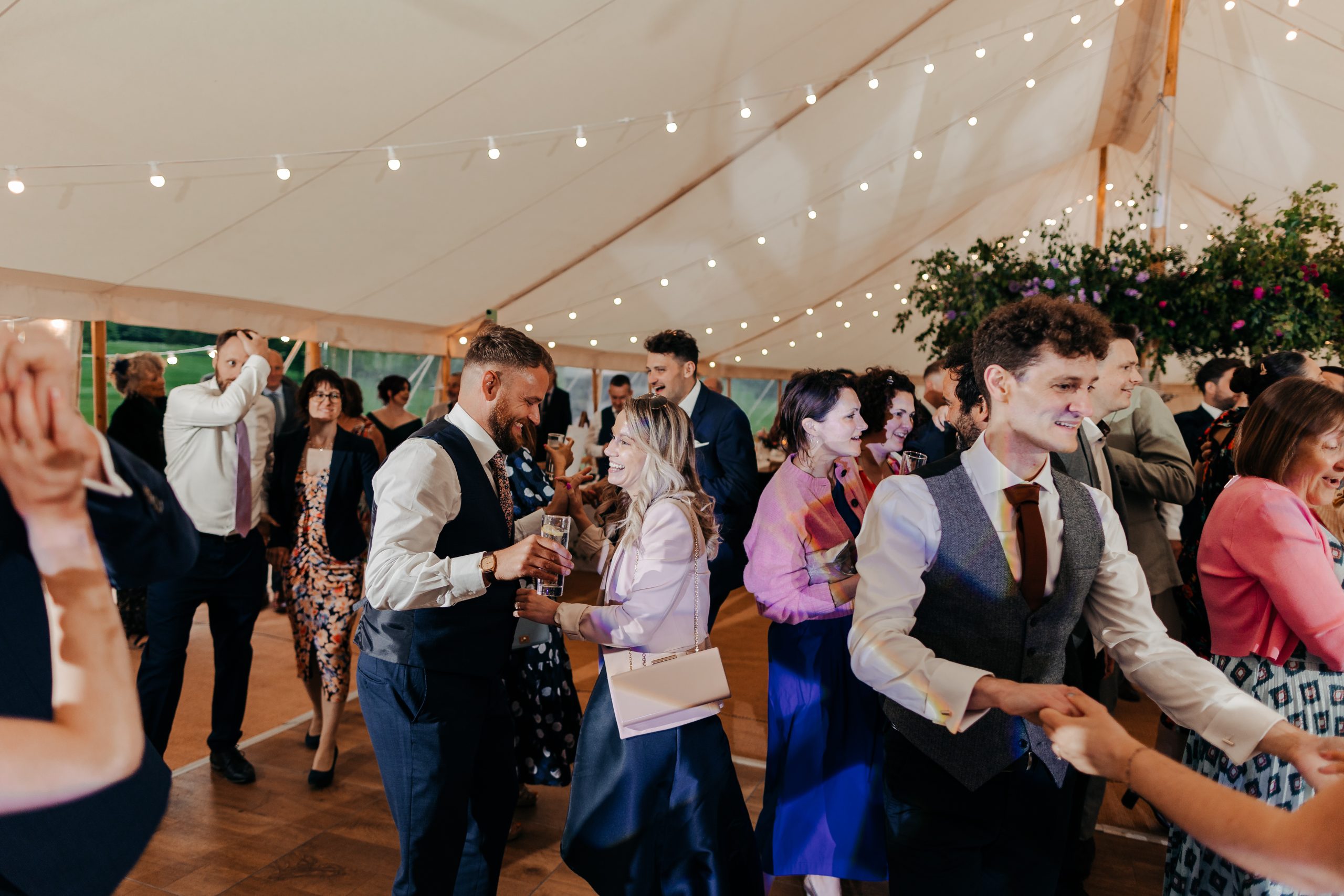 wedding guests enjoying the evening reception of marquee wedding at Helmingham Hall in Suffolk