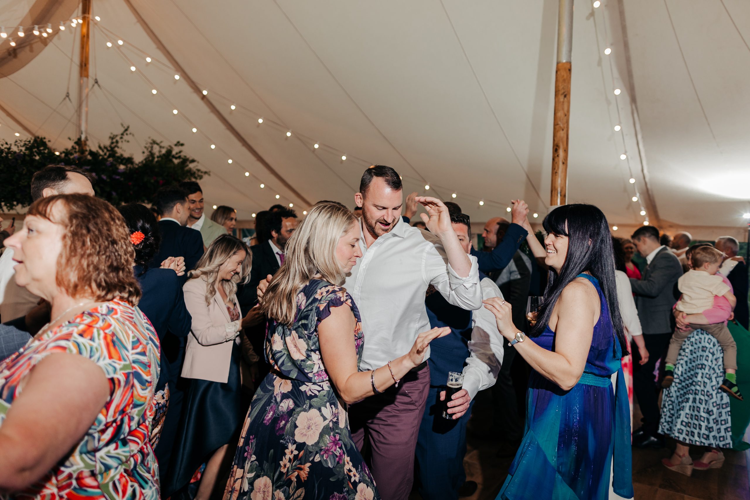 wedding guests enjoying the evening reception of marquee wedding at Helmingham Hall in Suffolk, coordinated by Hardesty Event Design