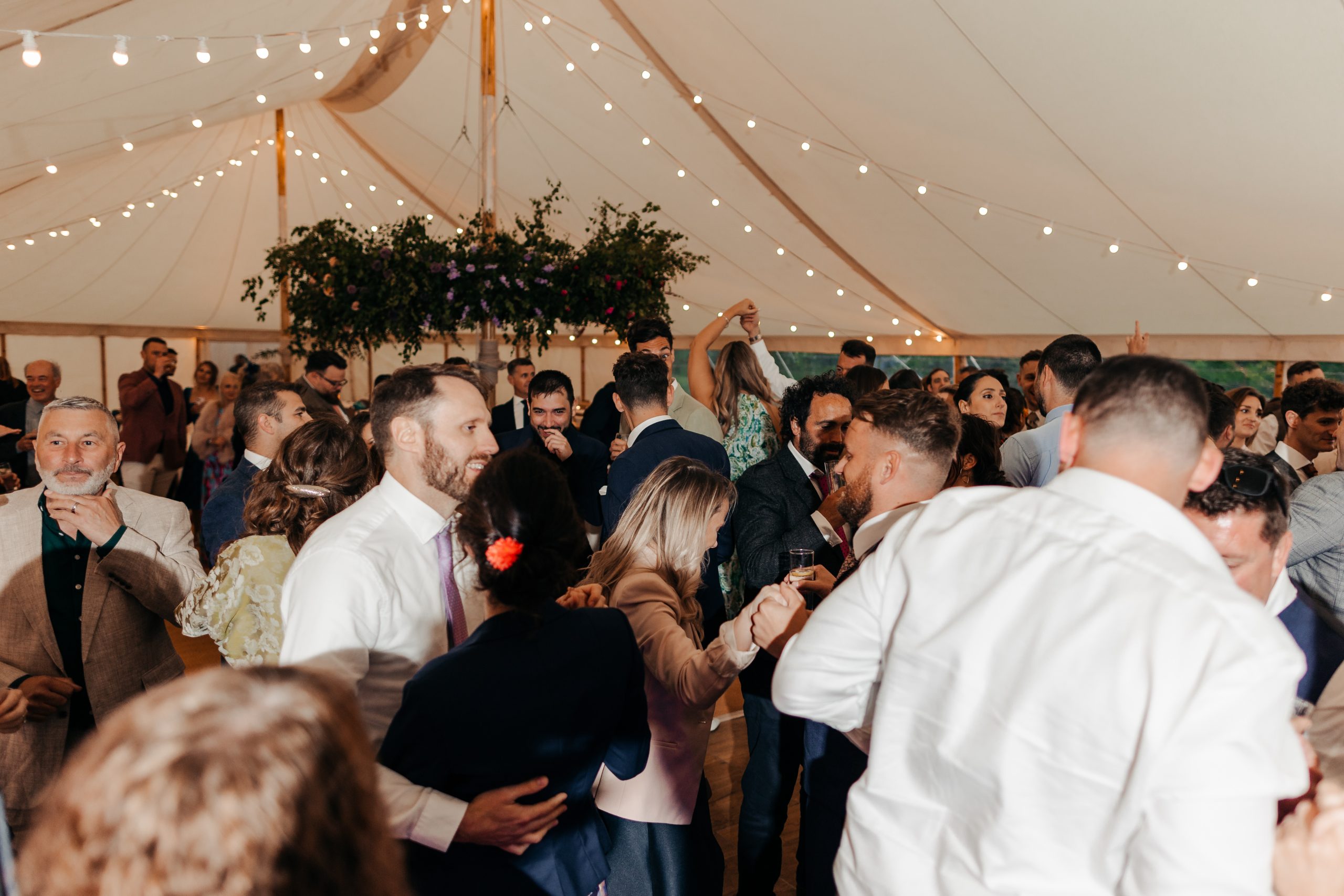 wedding guests enjoying the evening reception of marquee wedding at Helmingham Hall in Suffolk, planned by Hardesty Event Design