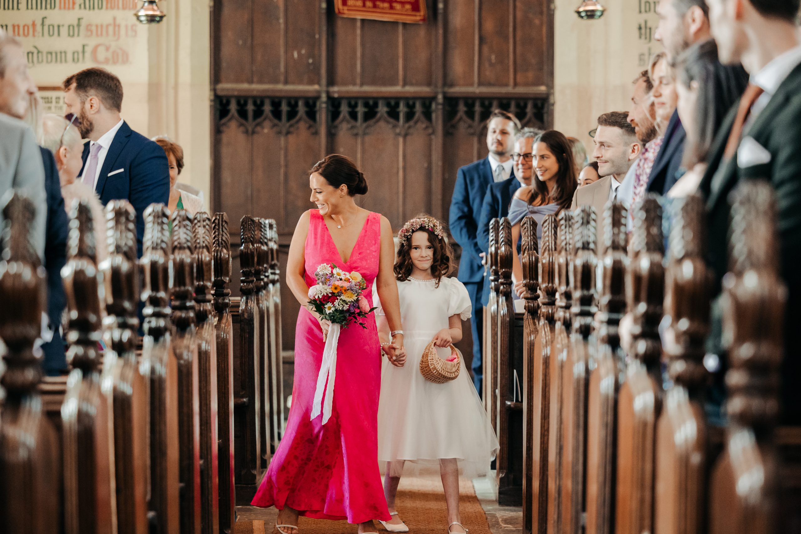 bridesmaids and flower girls walking up the aisle at a church ceremony in suffolk coordinated by Hardesty Event Design