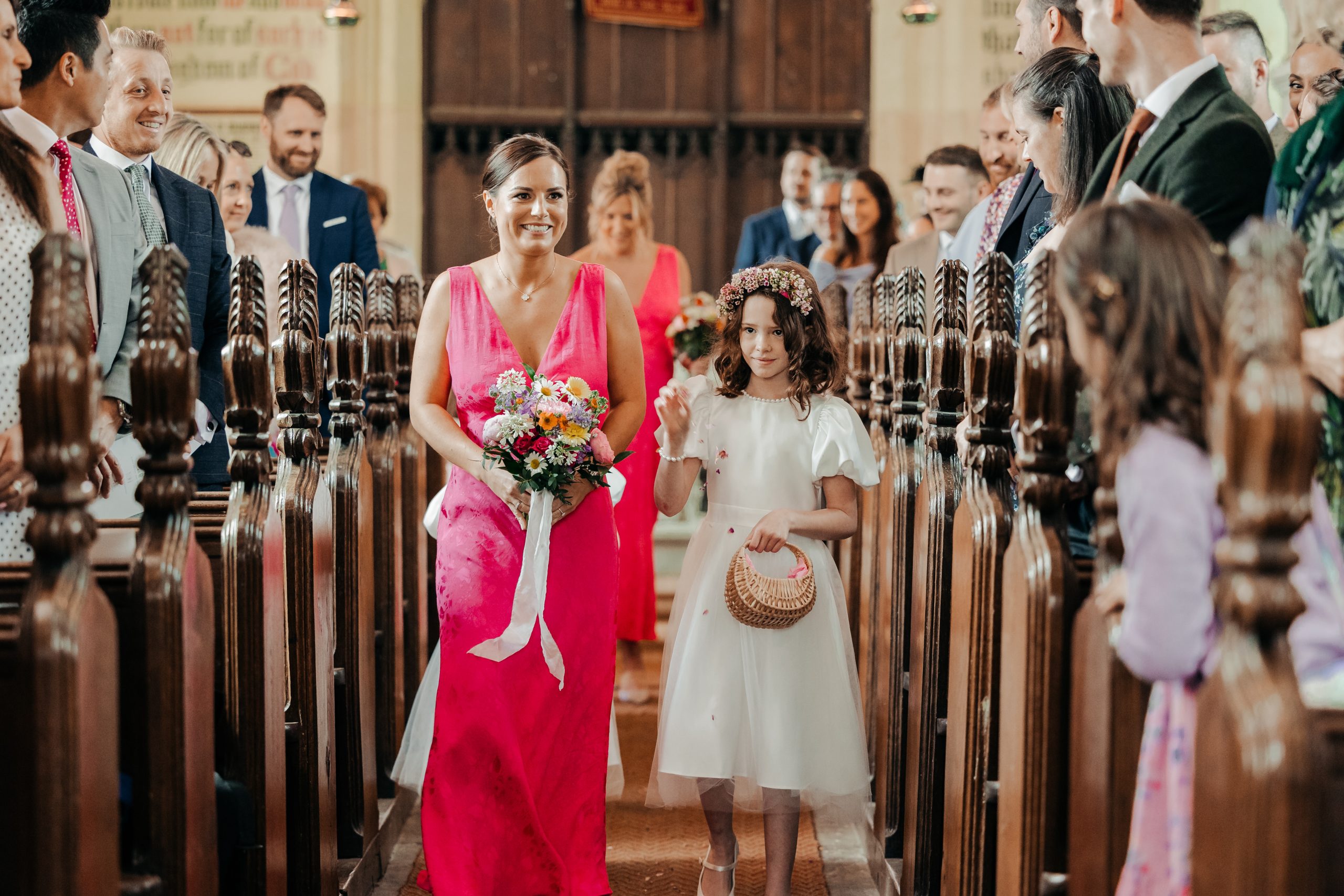 Elegant marquee wedding at Helmingham Hall planned by Hardesty Event Design. Bridesmaid and flower girl walking down the aisle