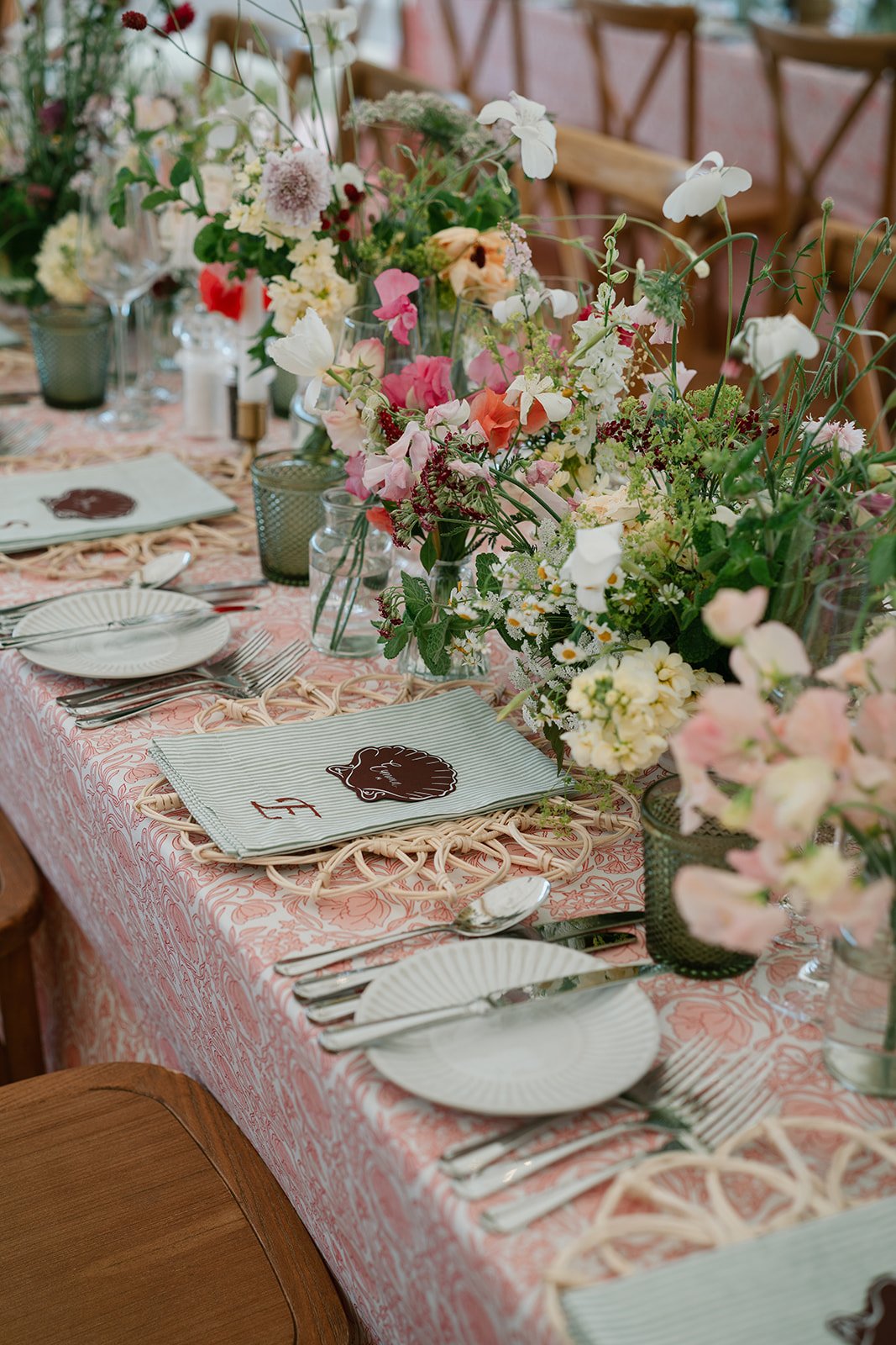 Warm and elegant tablescape with hand-printed tablecloths and abundant flowers for a luxury marquee wedding by Hardesty Event Design