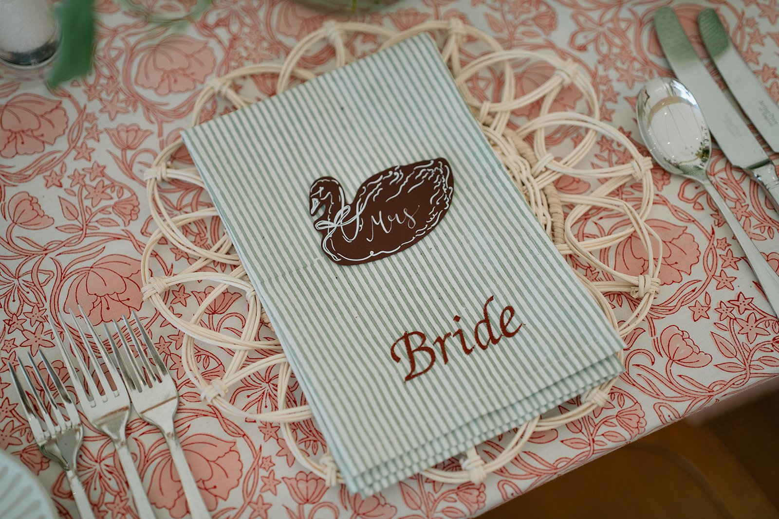 Intricately patterned table linen in rich red and coral tones, hand-printed for a personal wedding design