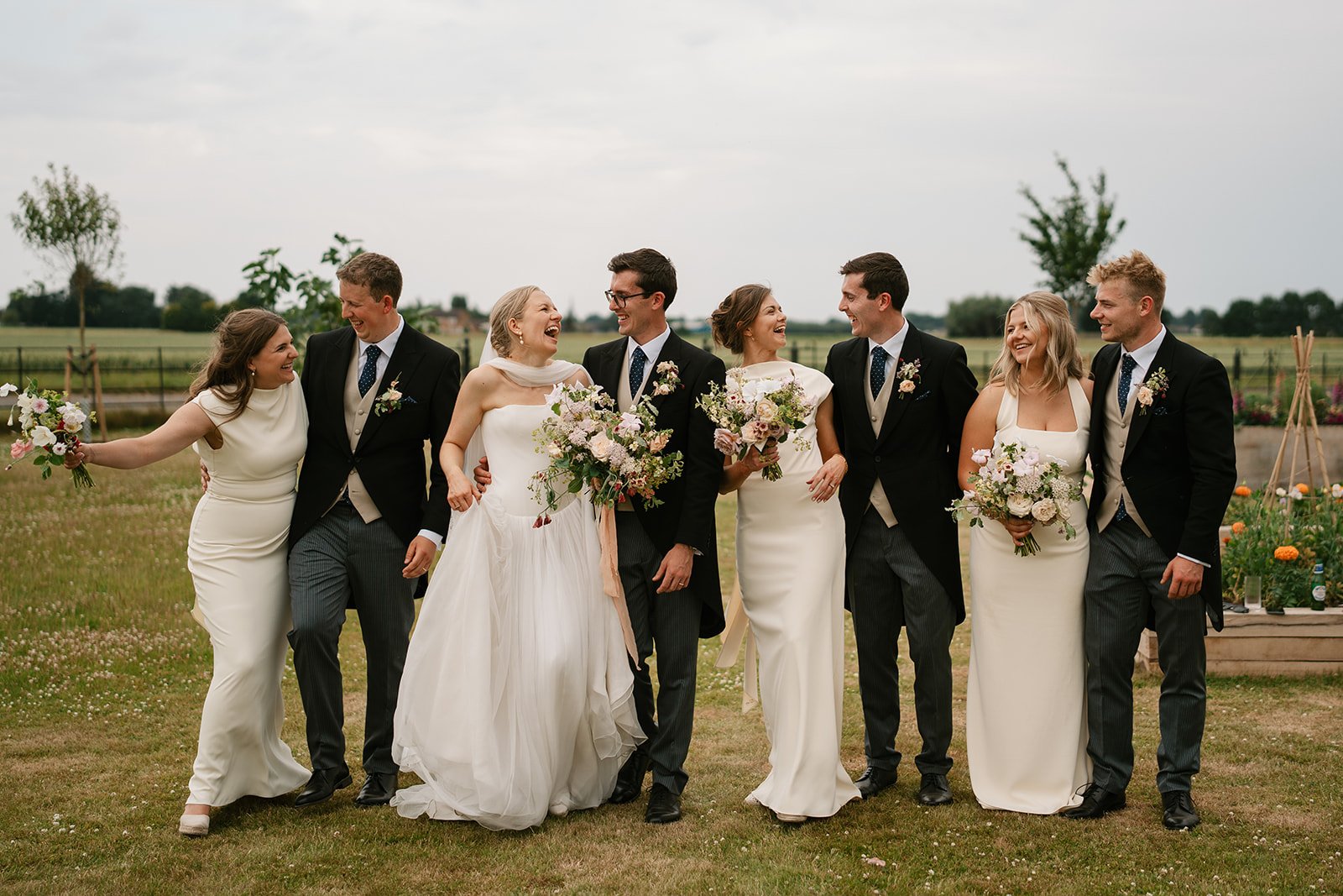 bride and groom with their bridal party on the day of the wedding wearing nanvy morning suits and lemon Odd Muse bridesmaid dresses