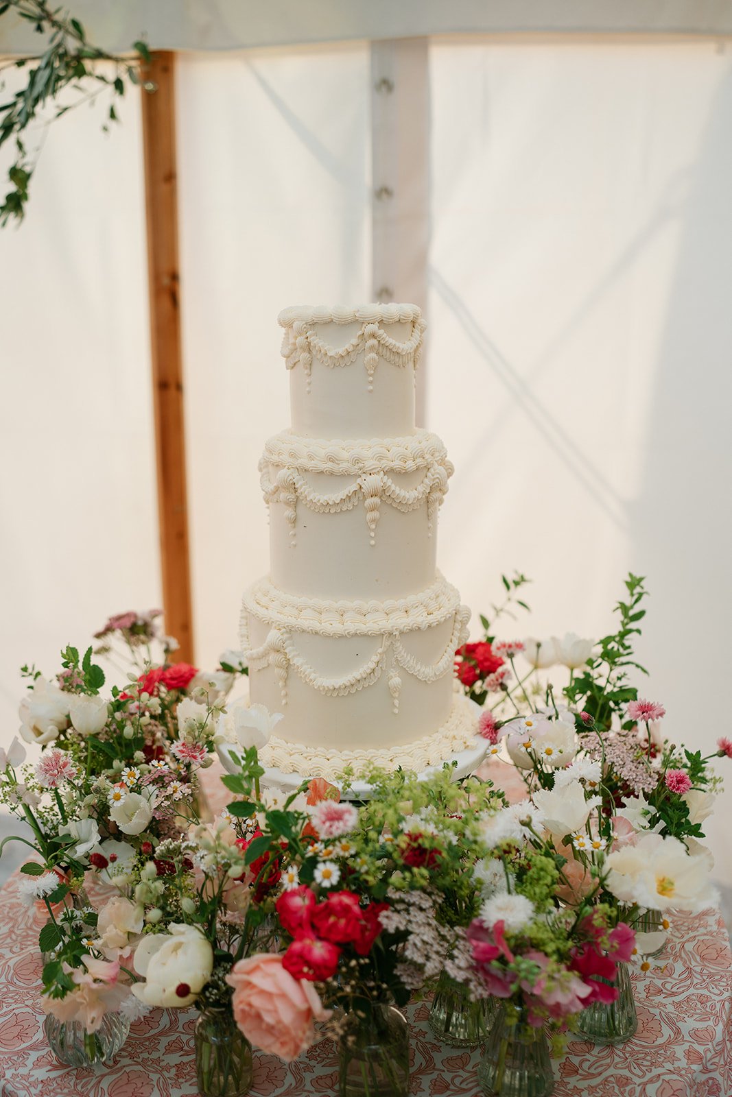 cream piped wedding cake in a traditional design for an elegant, warm wedding reception in a marquee in Lincolnshire