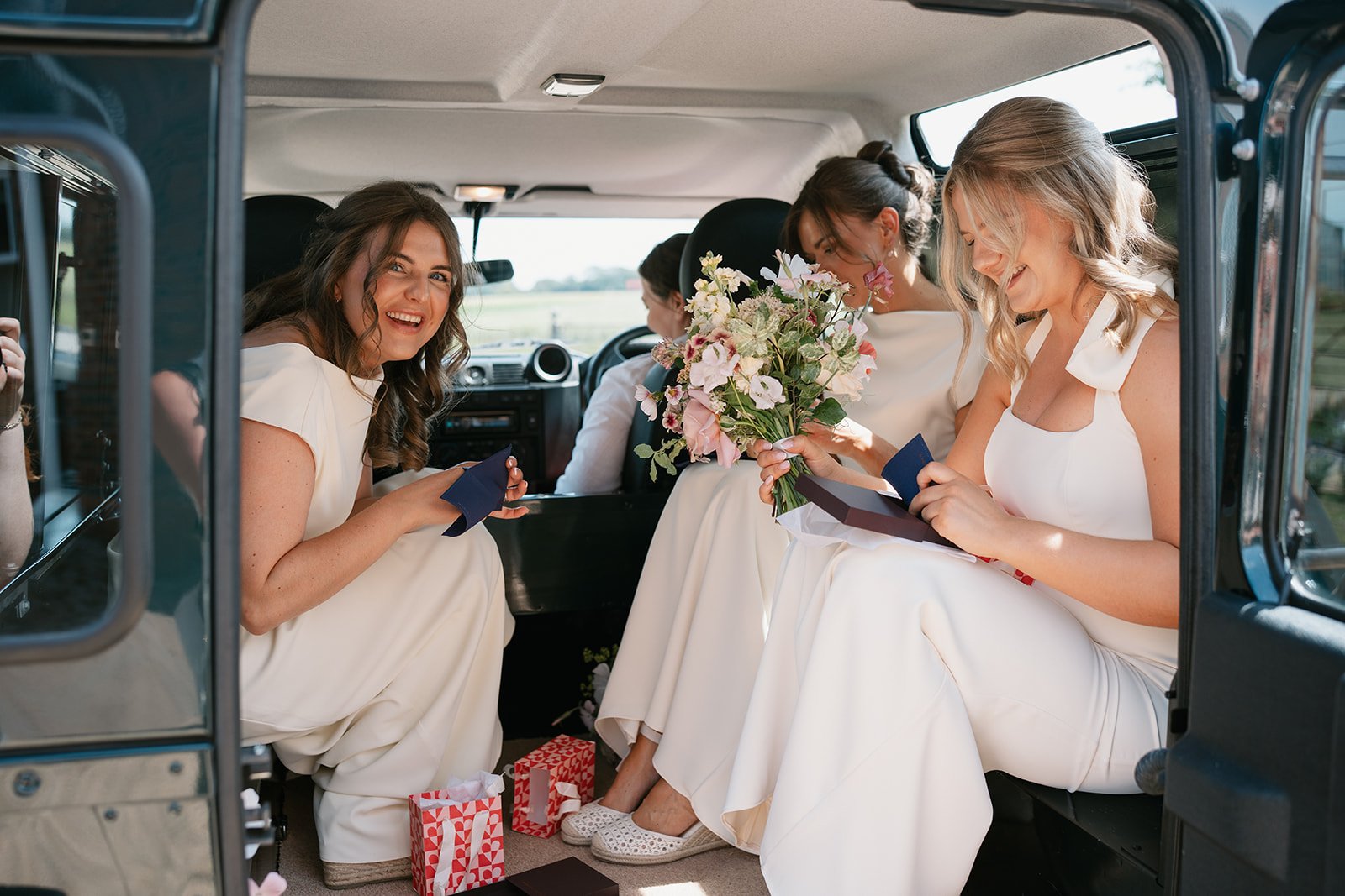 Cream, pink and coral floral arrangements with bride and bridemaids before ceremony, wedding styled by a UK luxury wedding planner