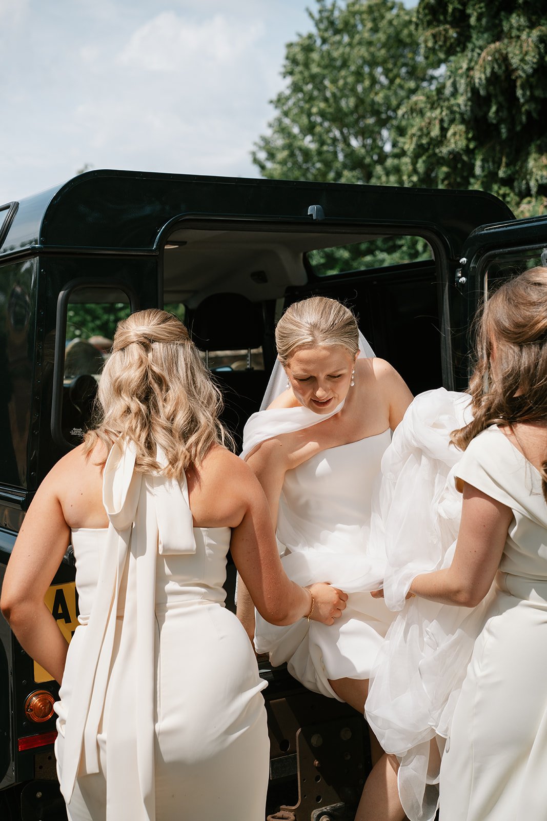bride being helped out of the wedding Land Rover by bridesmaids before church ceremony, coordinated by Hardesty Event Design