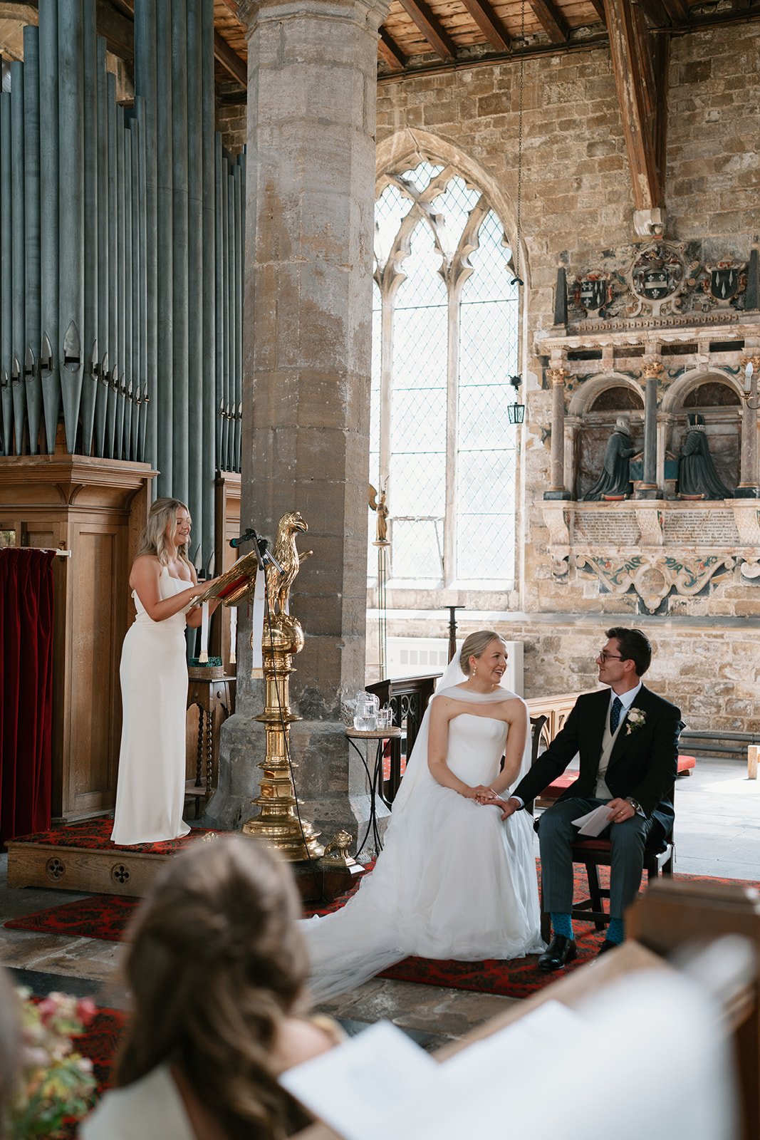 Bride and groom at church ceremony, listening to a reading by the maid of honour, coordinated by Norfolk uk wedding planners Hardesty Event Design