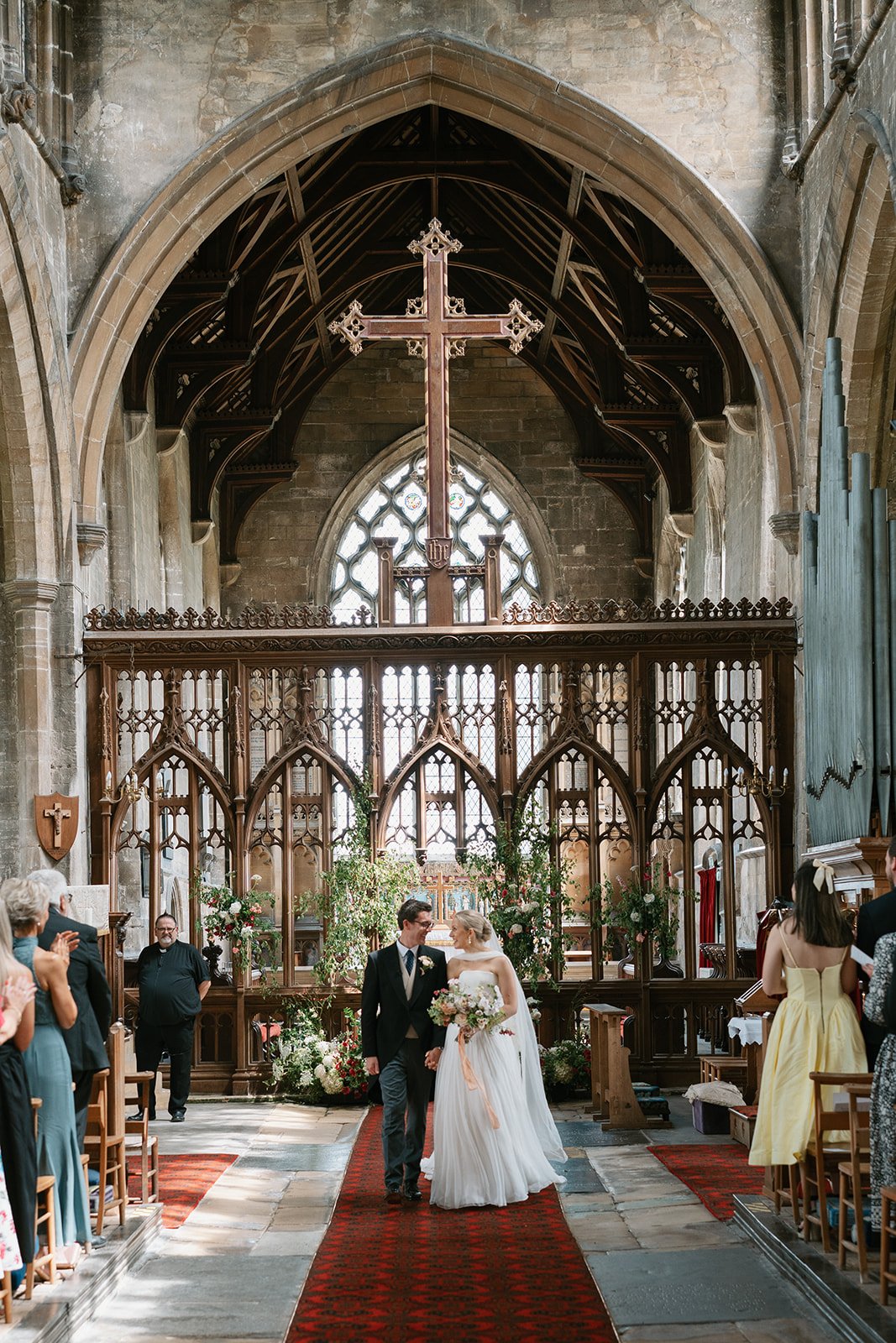 Bride and groom leaving their church ceremony at a high-end country house wedding in Norfolk planned by a luxury UK wedding planner