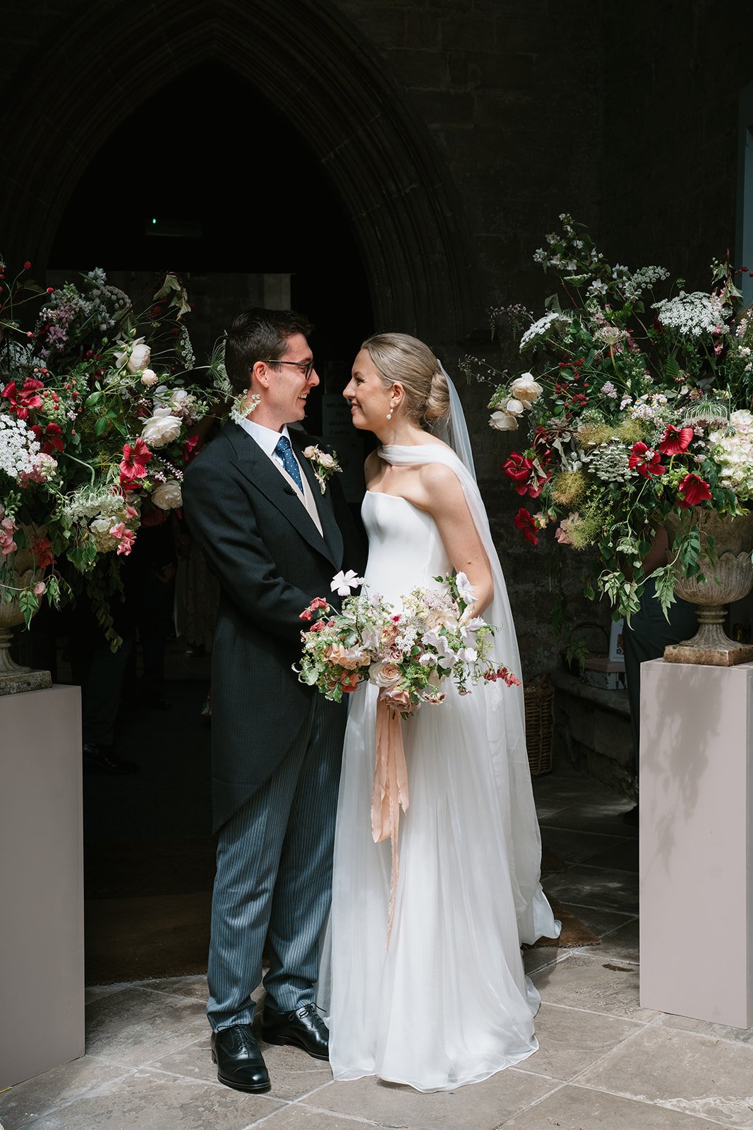 Bride and groom exchanging a glance at eachother at a high-end country house wedding in Norfolk planned by a luxury UK wedding planner