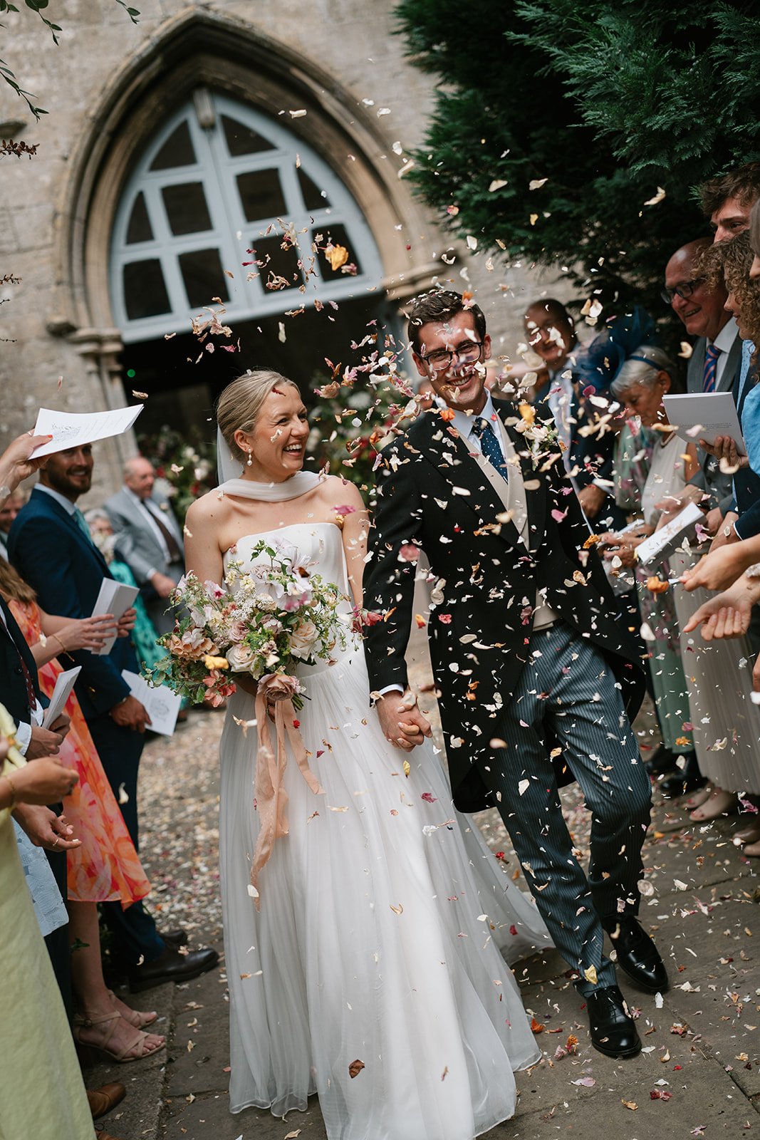 a confetti moment for charlotte and ed outside the church during their luxury marquee wedding in Lincolnshire
