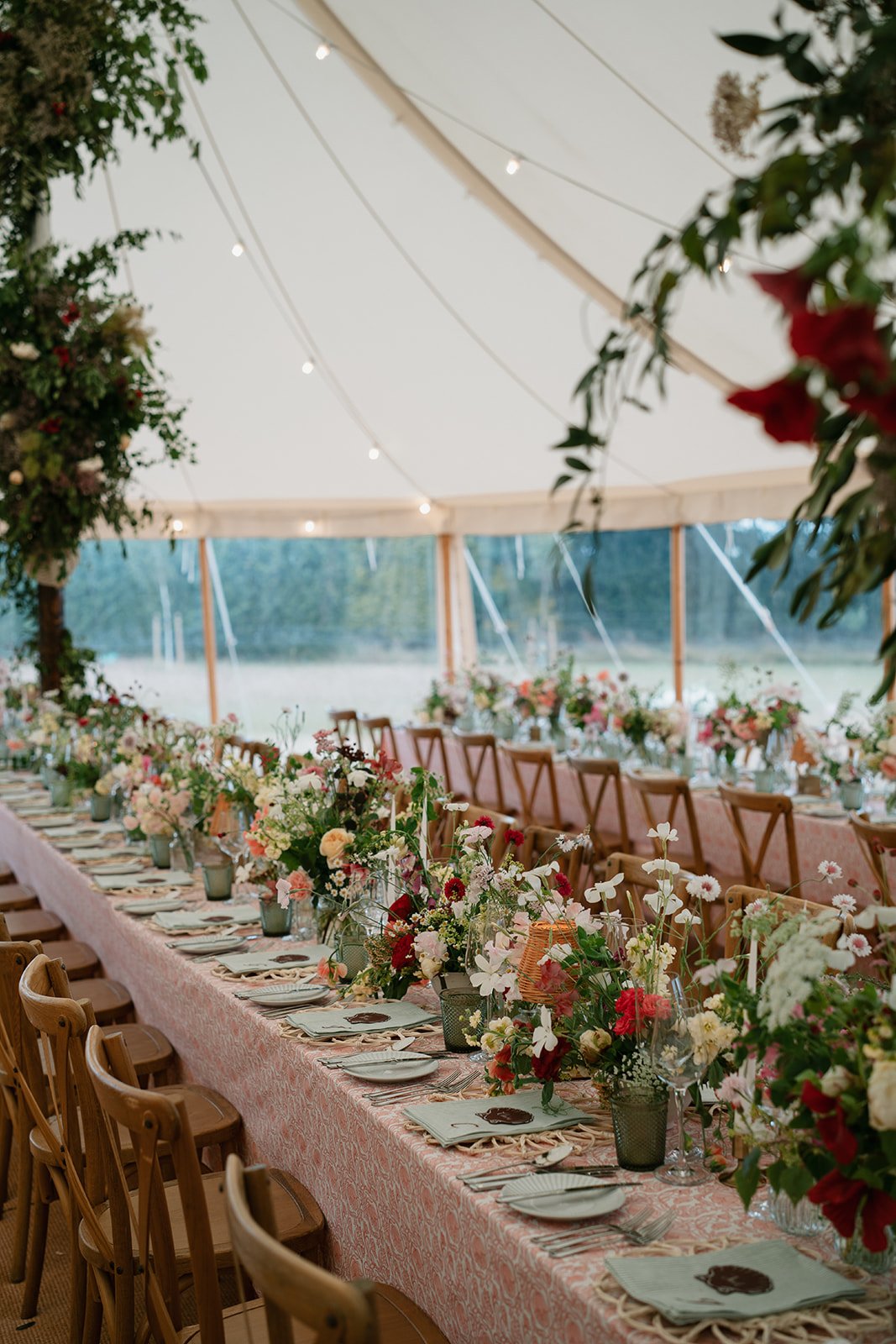 Intricately patterned table linen in rich red and coral tones, hand-printed for a personal wedding design paired perfectly with gorgeous wedding blooms