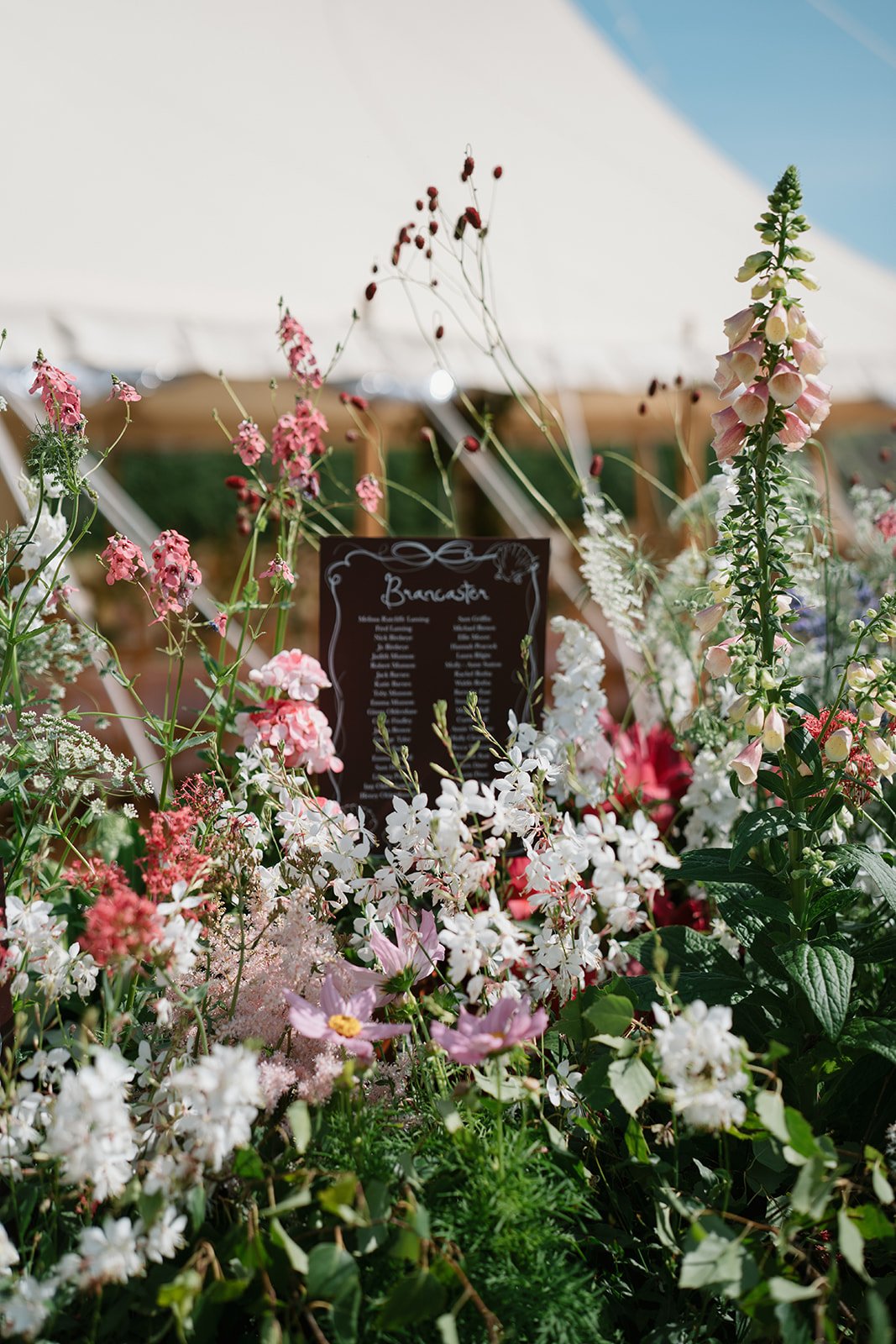 Cream, pink and coral floral arrangement in a marquee wedding styled by a UK luxury wedding planner