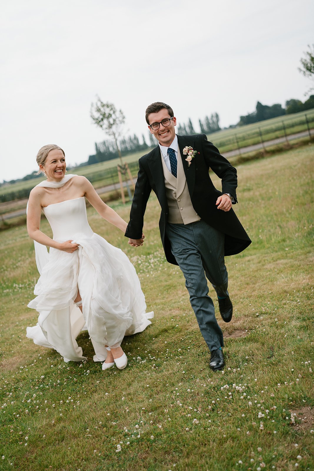 Bride and groom running together in their garden marquee wedding, coordinated by Hardesty Event Design