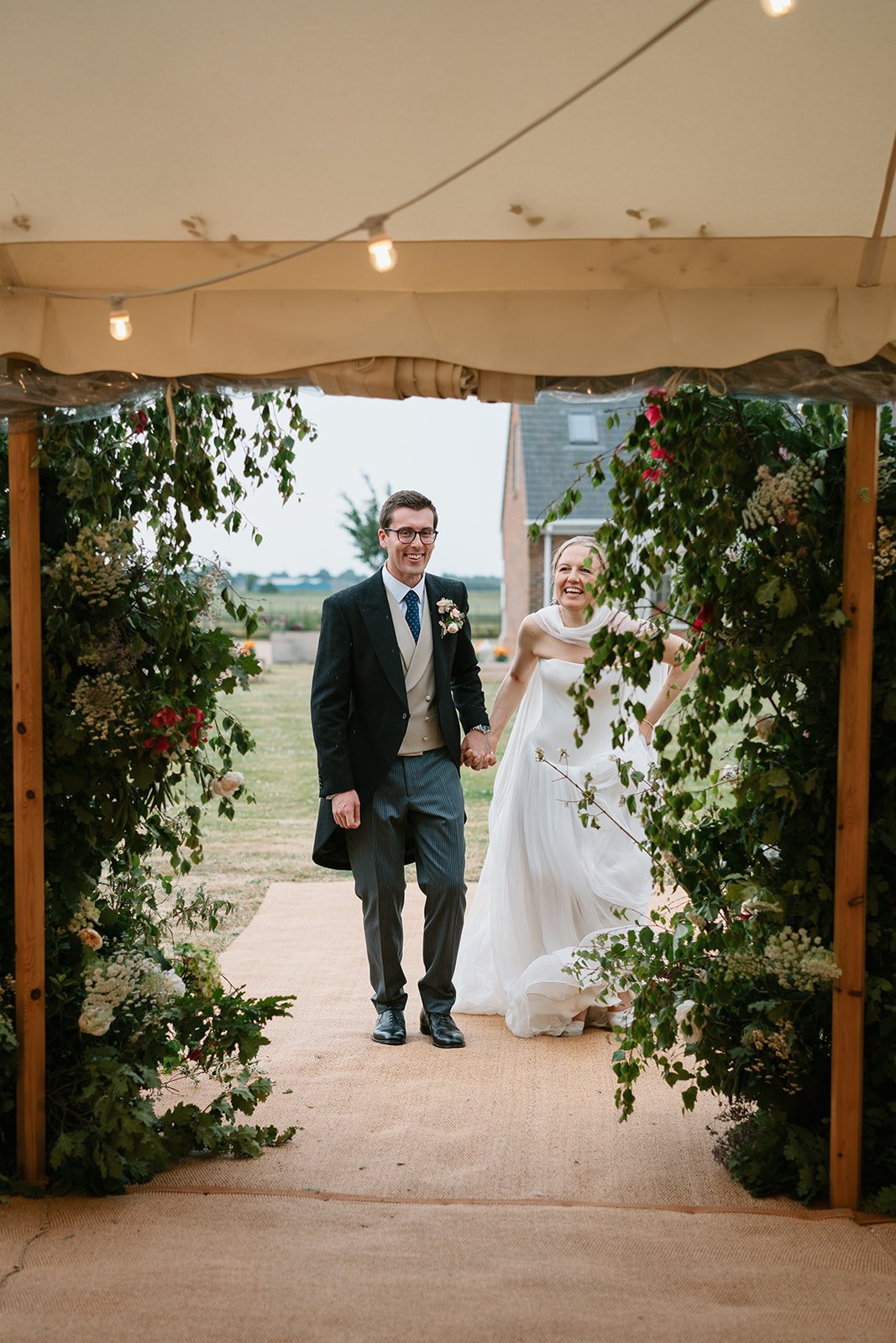 Bride and groom standing together for their annoucement into the marquee at their garden marquee wedding, coordinated by Hardesty Event Design
