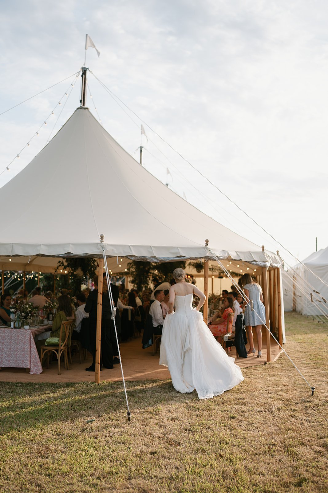 bride entering into her at-home marquee wedding reception coordinated by Hardesty Event Design