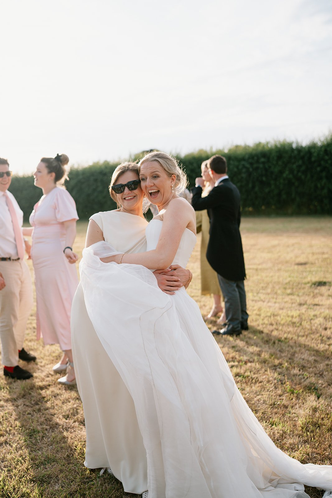 bride and bridesmaid enjoying a joyful moment together at a sophisticated marquee wedding planned by Hardesty Event Design