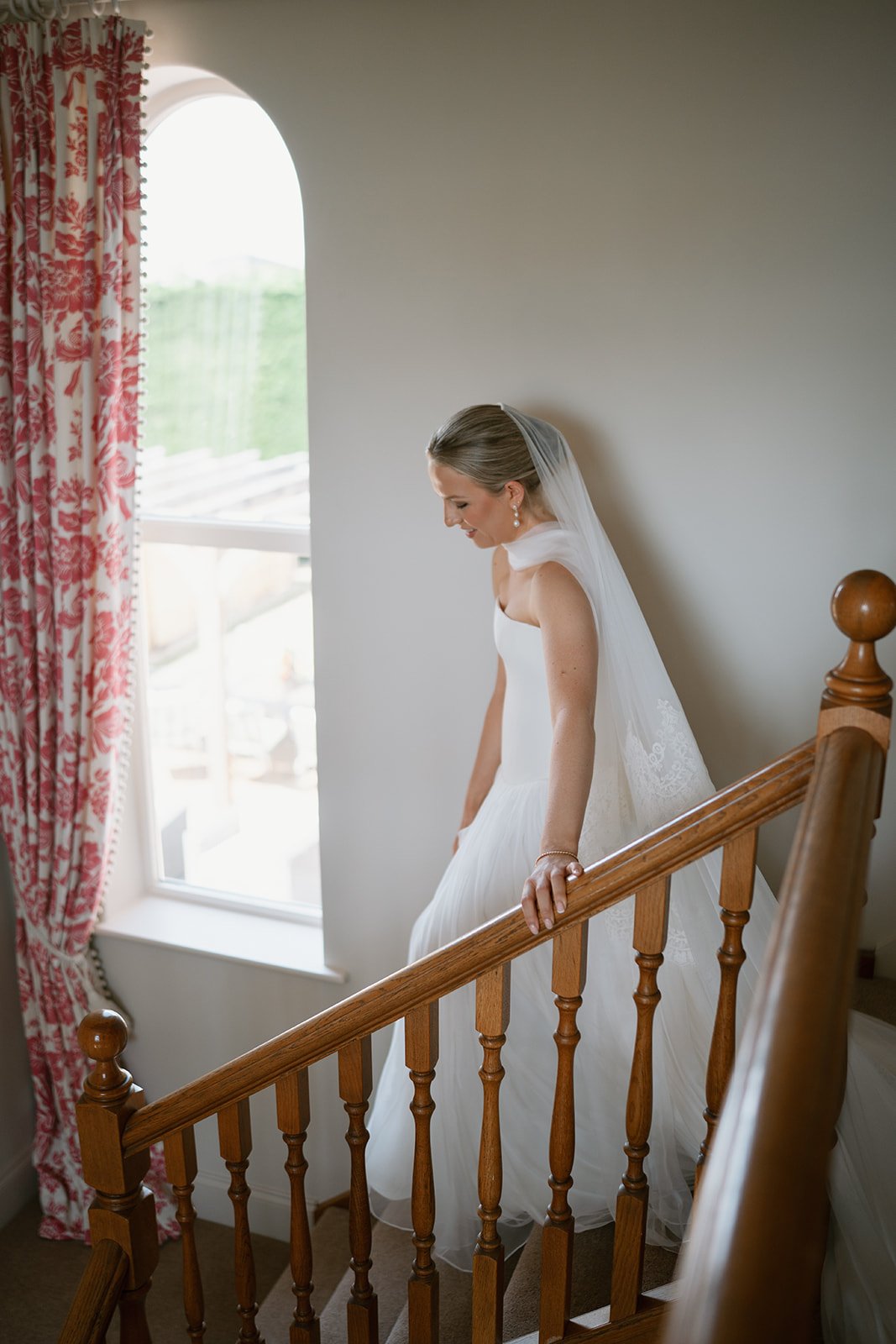 Emma Beaumont bride, Charlotte walking down the staircase for the first time in her wedding dress before getting married in church, coordinated by wedding coordinator Hardesty Event Design